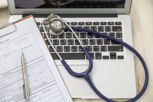 Stethoscope and prescription on laptop